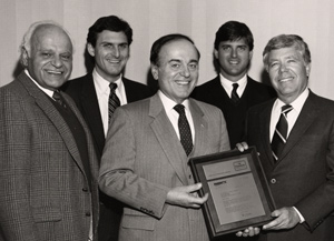 1986 Al Jordan, President of Fabritec International, presenting a plaque to Arthur Anton, Sr., commemorating Anton’s 50 years as a Sanitone licensee. From left to right: Owners Soc and Arthur Anton with Al Jordan. Sons Charles and Arthur in background represent the third generation in the family business.